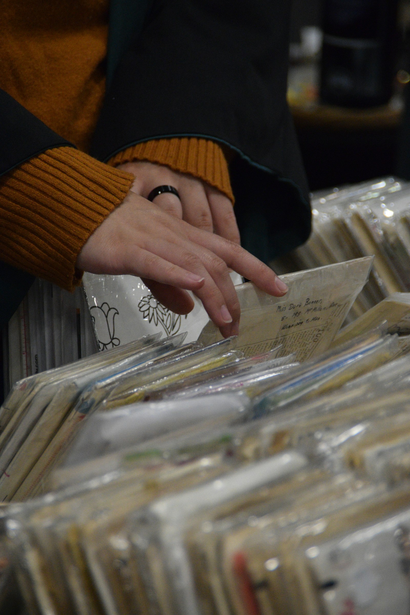 Hands flipping through records in a shop bin