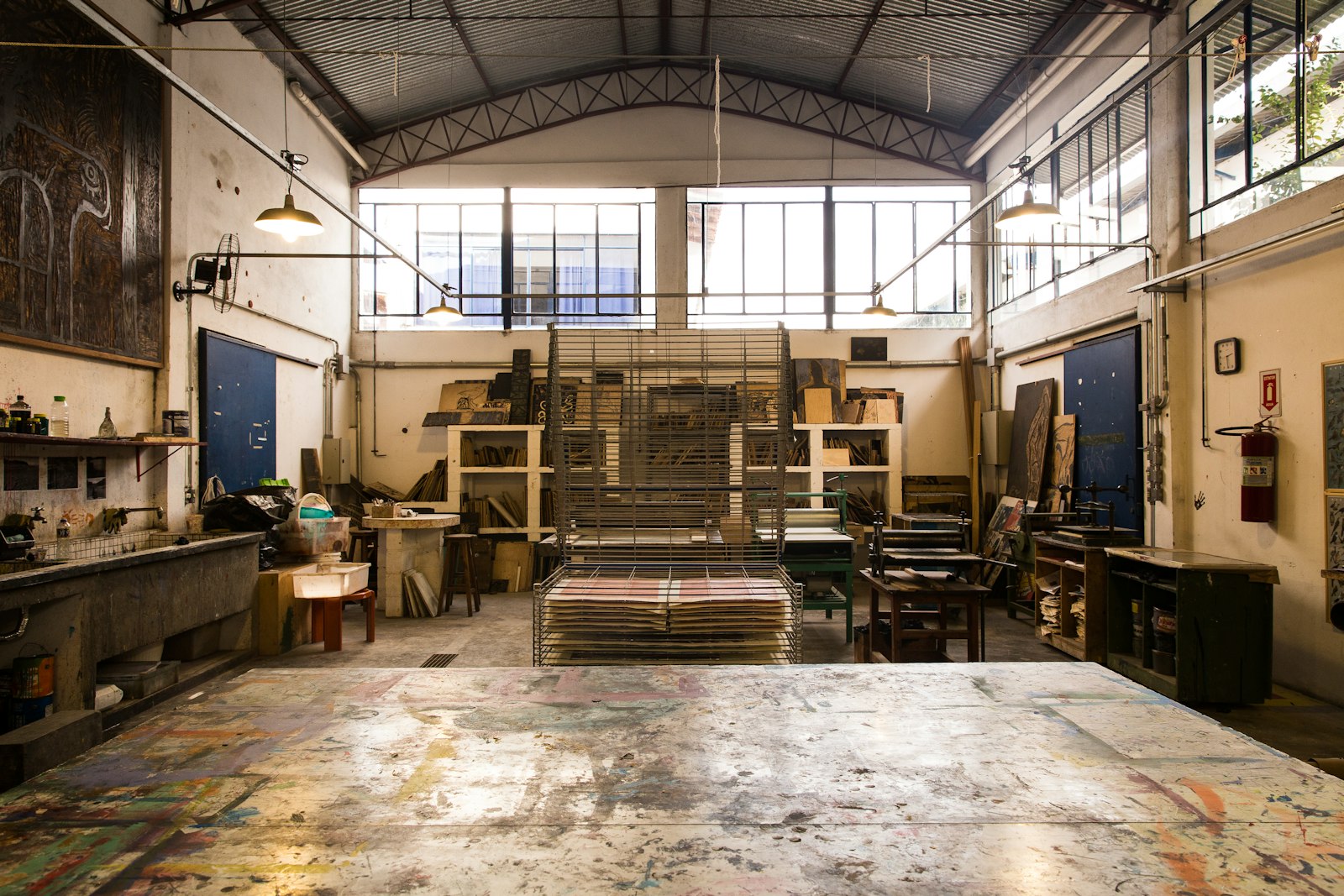Large print workshop with tall windows and a paint-splattered floor