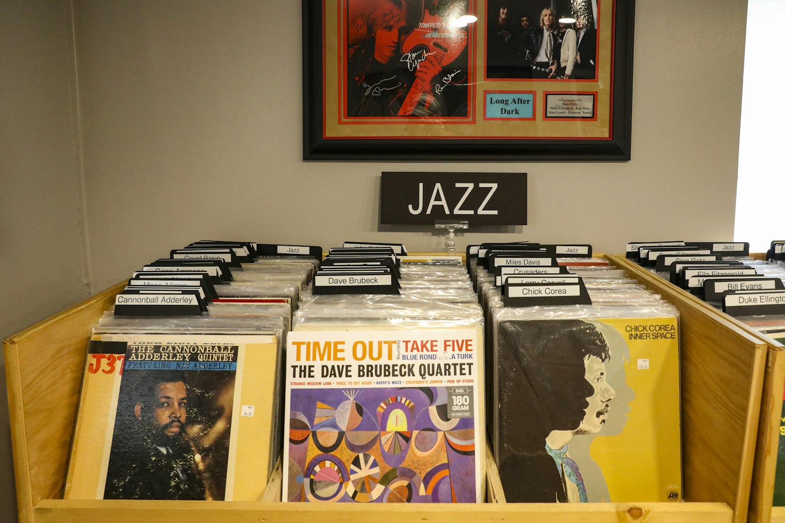 Jazz records in a bin beneath a framed poster