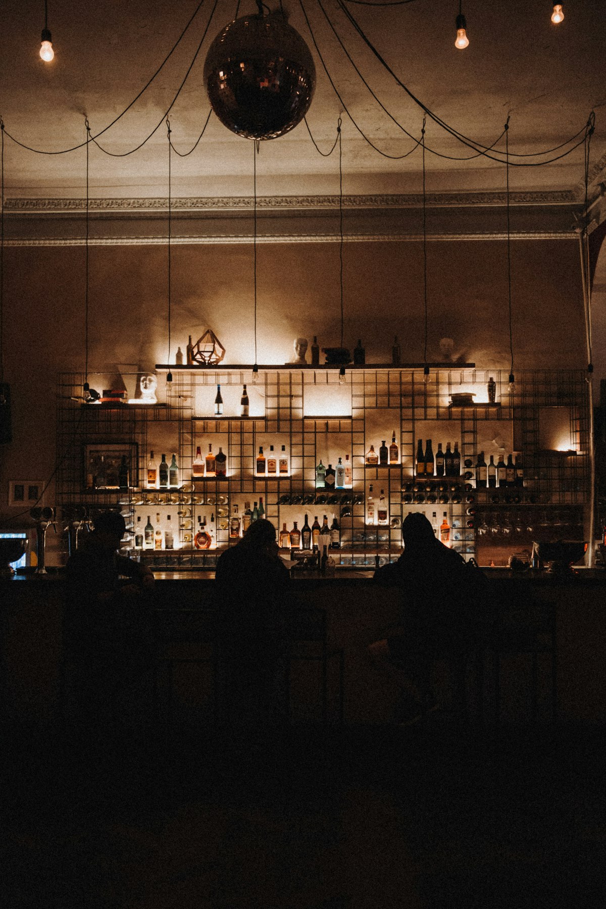 Two people sitting at a dimly lit pub bar