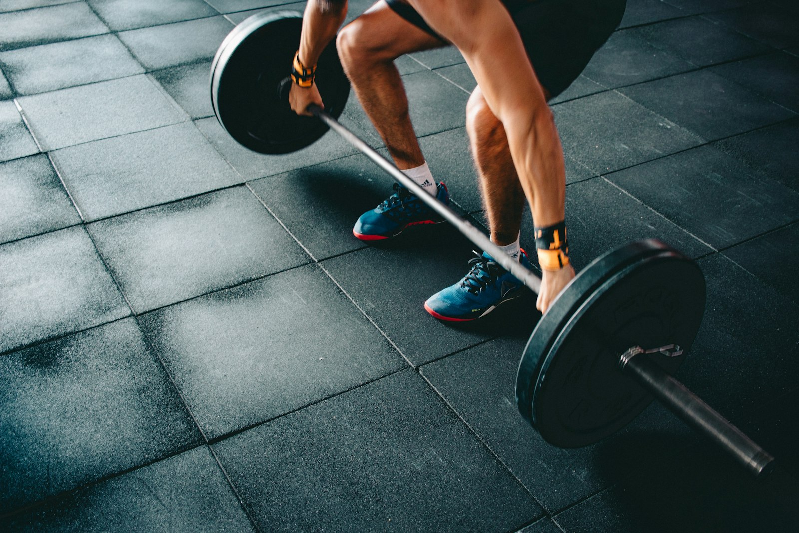 Athlete pulling a loaded barbell in a training gym