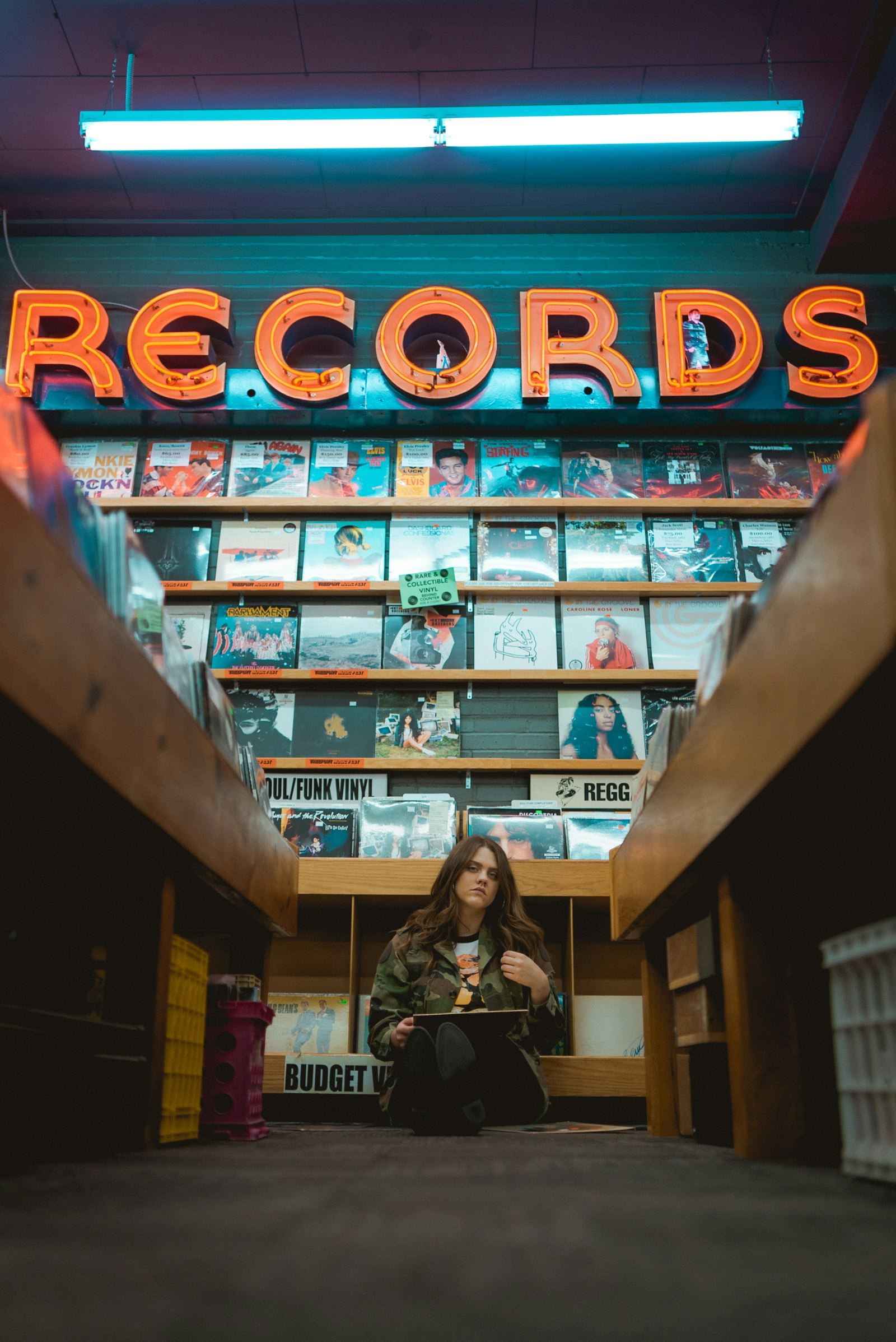 Record store aisle under a neon RECORDS sign