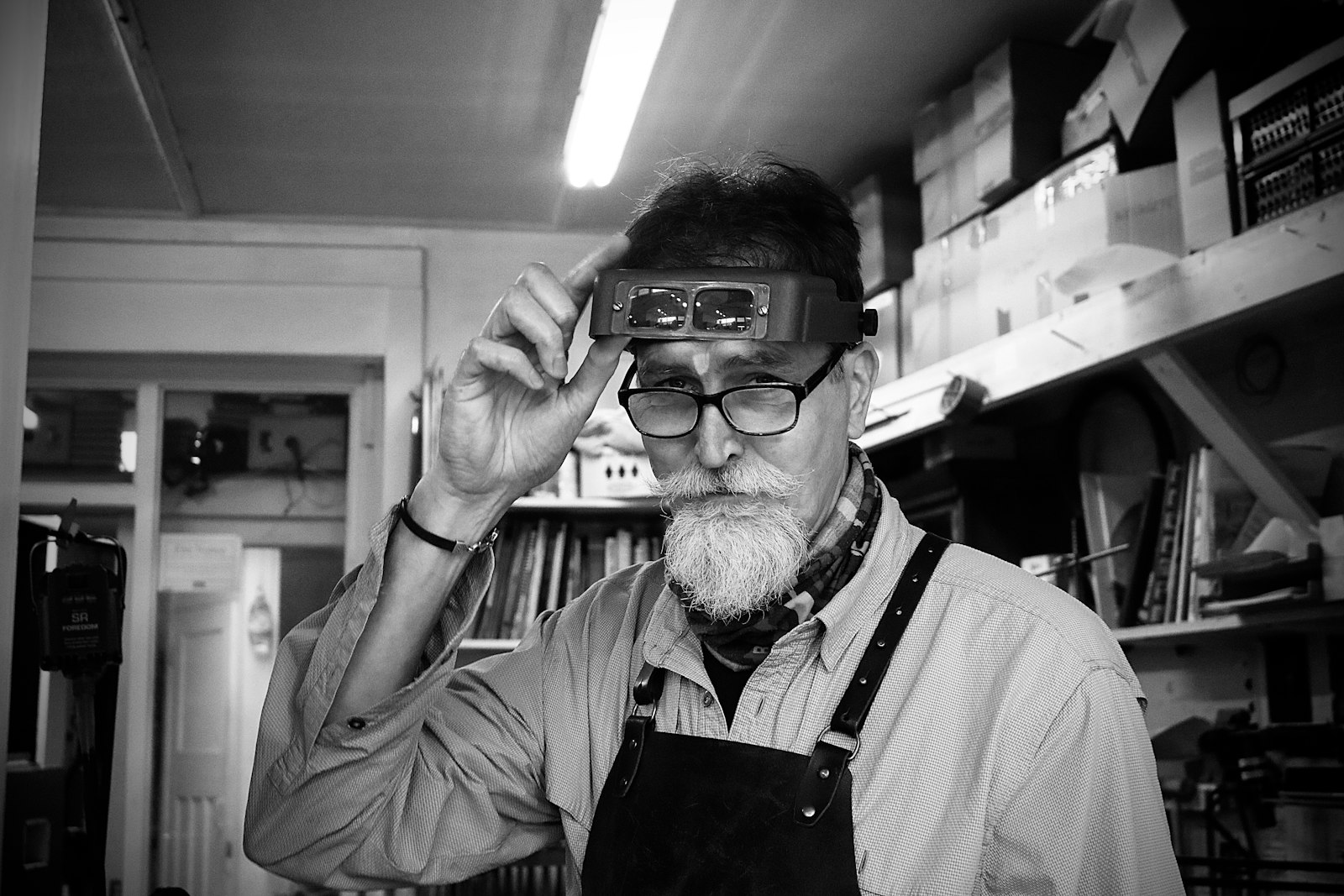 Man wearing a magnifying loupe in his workshop