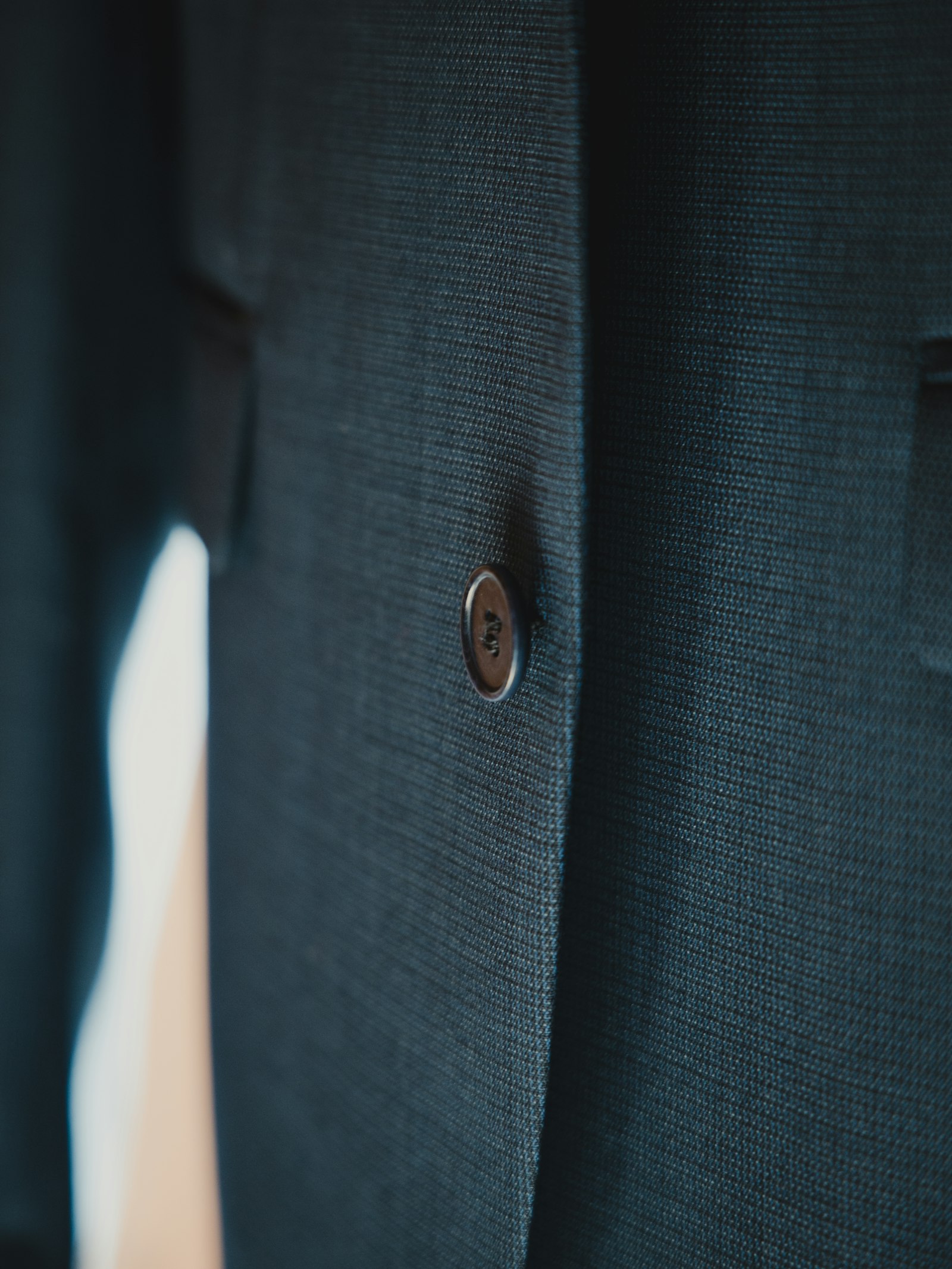 Close-up of a dark jacket with a single button