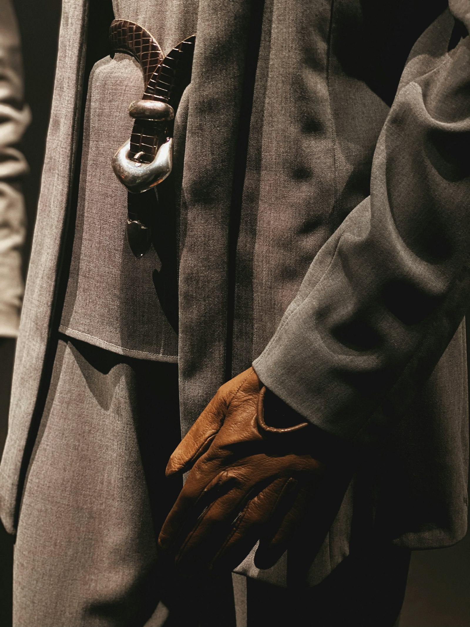 Man in a tailored suit and leather gloves