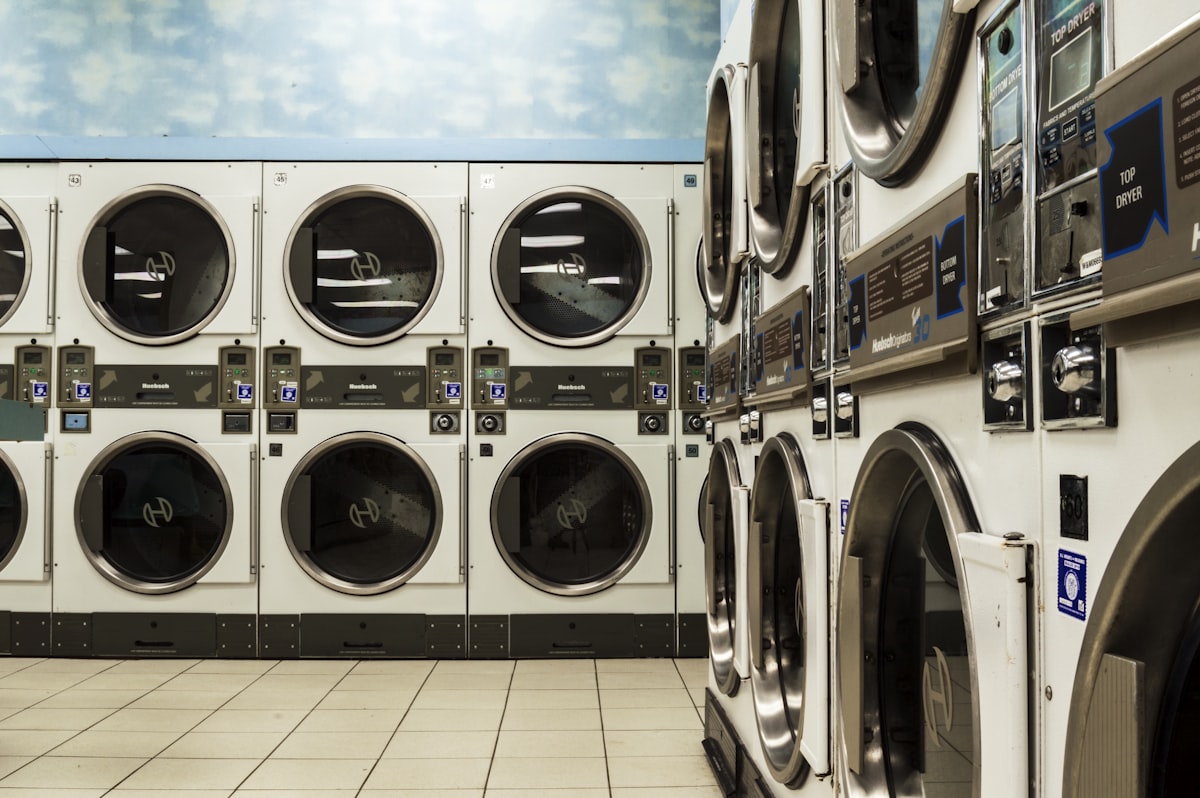 Rows of stacked dryers in a laundromat with tiled floor