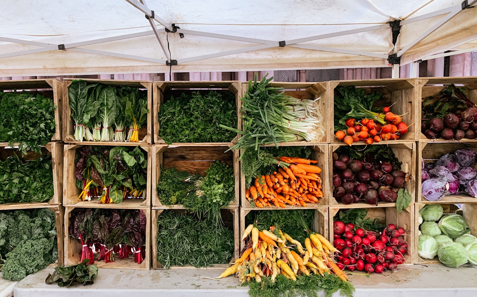 Fresh vegetables displayed in wooden market crates