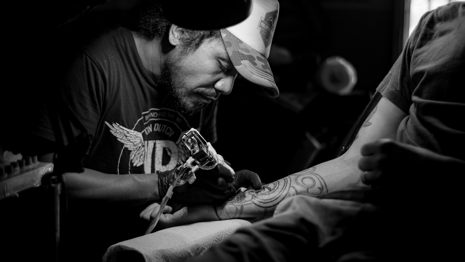 Tattoo artist working on a client under studio light