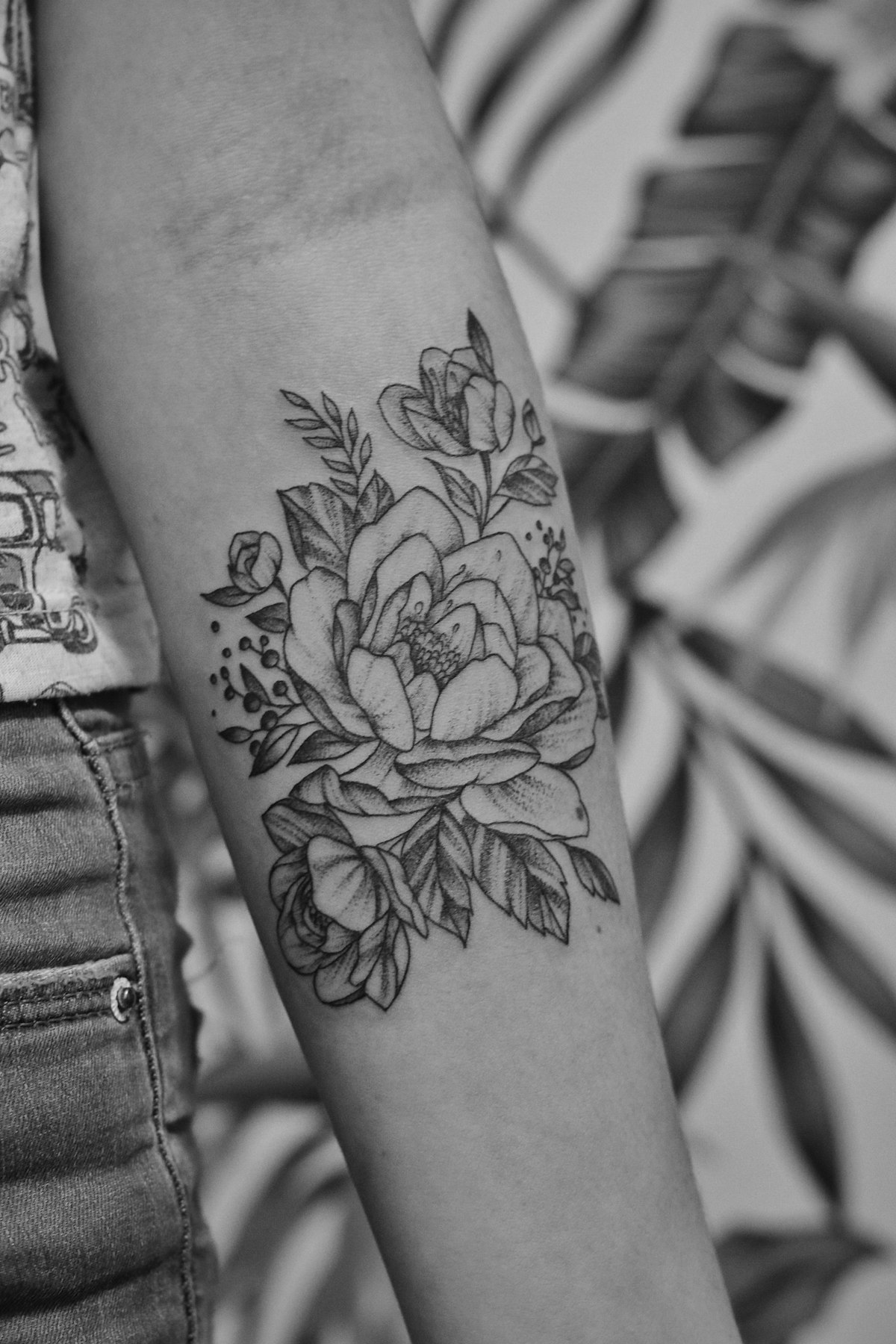 Healed floral blackwork tattoo on a forearm